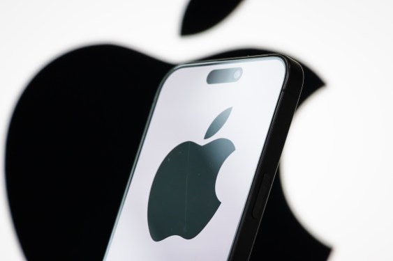 In this photo illustration, the logo of Apple Inc. is displayed on a smartphone screen, with the company's iconic black apple symbol visible in the background.