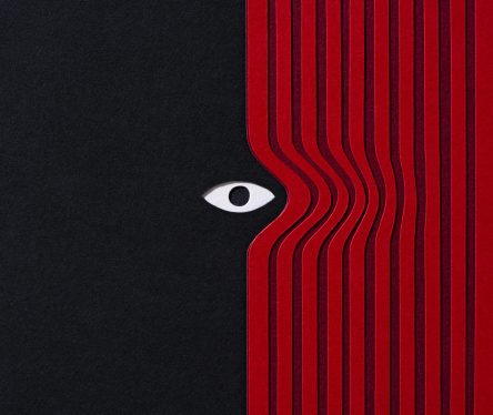 Paper Craft of Mysterious Eye Peering Out From Red Curtain on Black Background Front View.