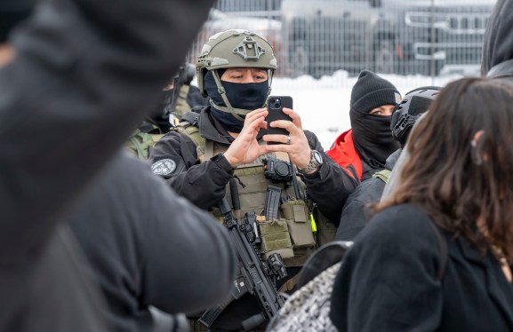 Minneapolis, Minnesota, January 8, 2026, Protest at the Whipple Federal building in response to the shooting of a woman by an Immigration and Customs Enforcement officer who killed the woman. Police agent taking video of the protesters on his phone. (Photo by: Michael Siluk/UCG/Universal Images Group via Getty Images)