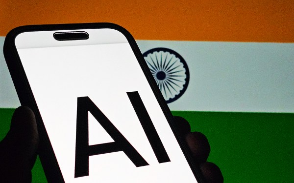 India flag with 'AI' displayed on smartphone screen in foreground
