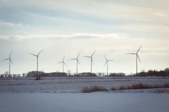 Wind turbines stand across open fields near a railway line in northern Poland, on January 10, 2026.